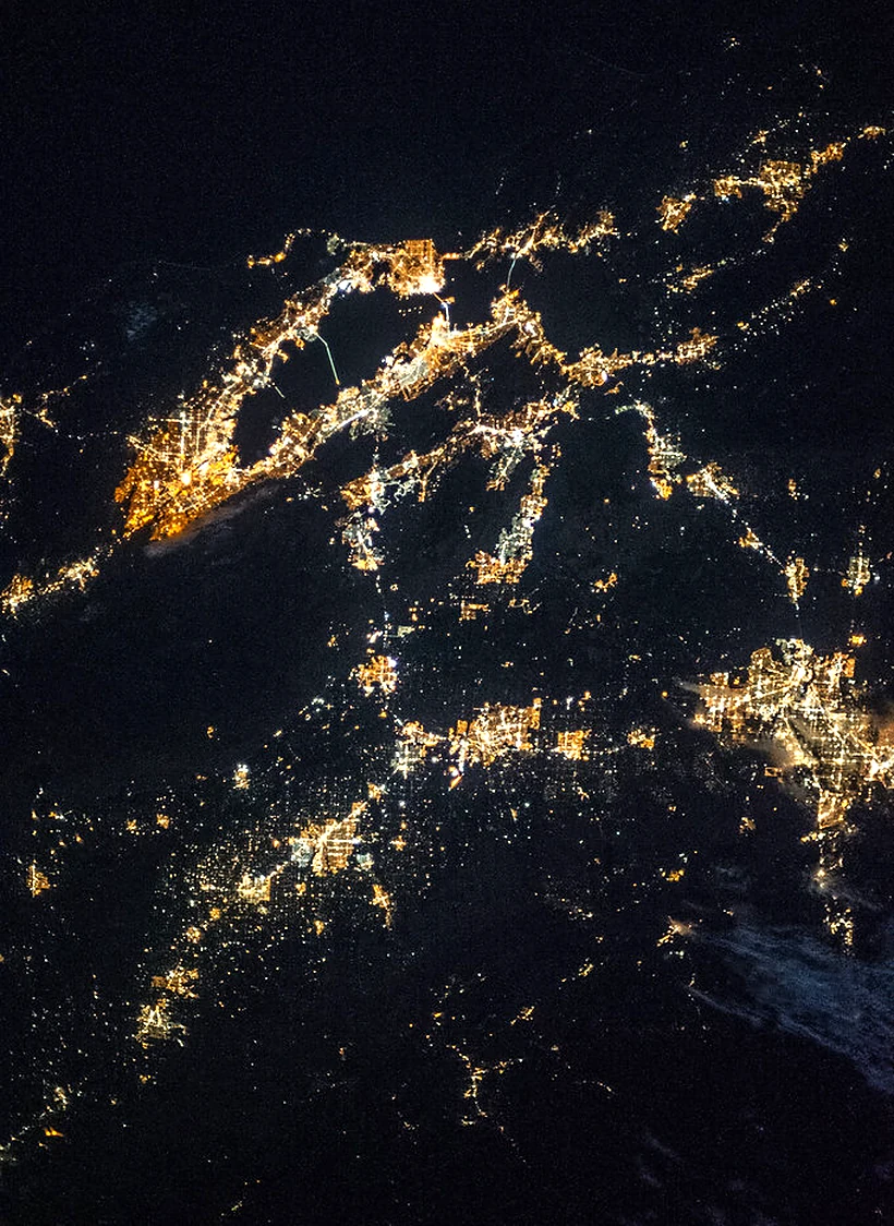 City lights along a coastline at night, seen from the International Space Station